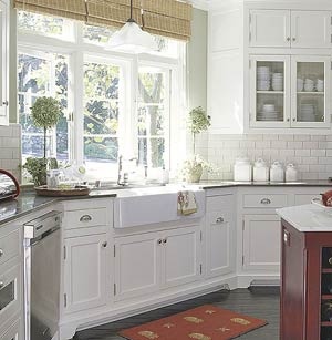 kitchen with farmhouse sink, white cabinets, and white subway tile