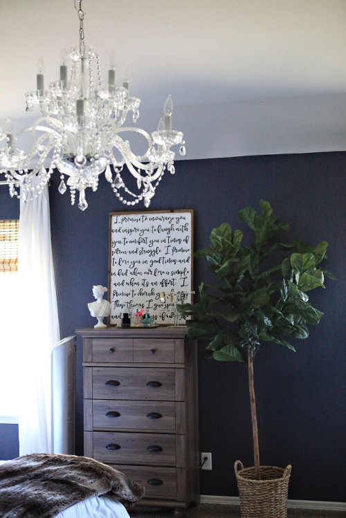 Master bedroom featuring navy walls, white bedding, tufted linen headboard and bench